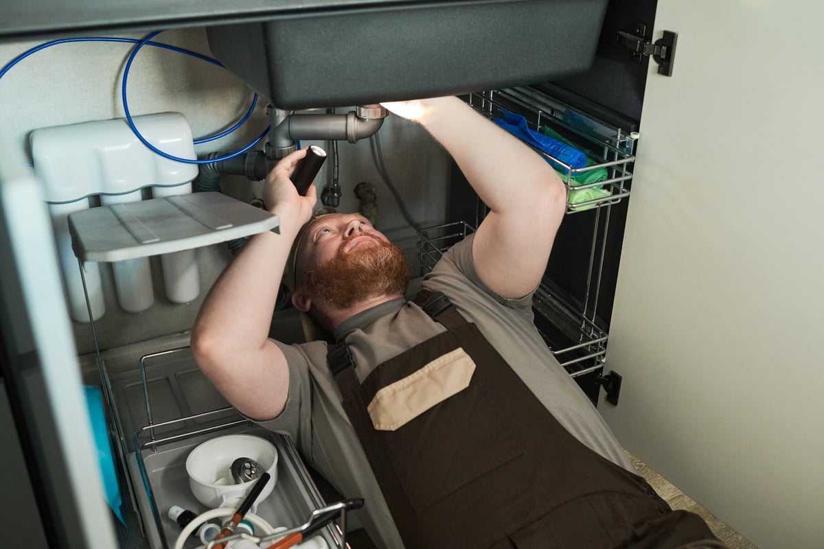 Professional technician installing water filtration system